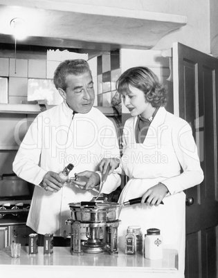 Couple together in the kitchen preparing a fondue