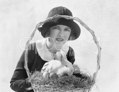 Young woman with an Easter basket and a bunny