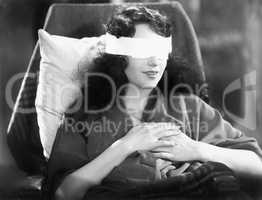 Young woman sitting in a chair with bandages over her eyes