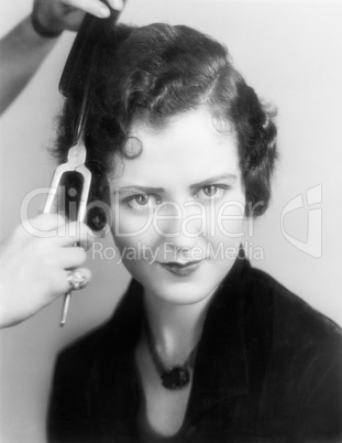 Young woman at the hairdresser having curls done