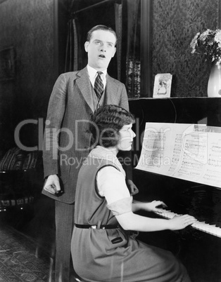 Man singing and woman playing the piano