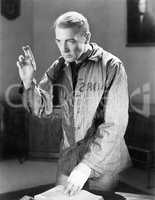 Man in a prisoners garb holding up his fingers swearing an oath