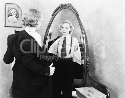 Young woman in men's clothing getting undressed in front of a mirror