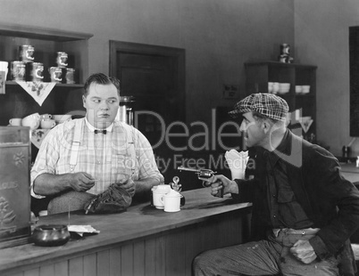 Man with a gun holding up a diner owner