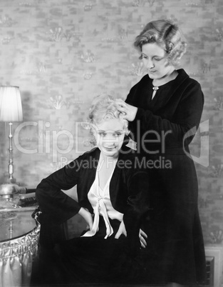 One woman helping her friend with her hair