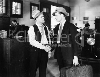 Two men shaking hands in a car shop