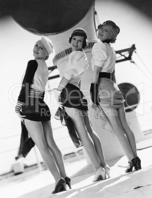 Three women looking over their shoulders and showing their legs