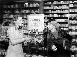 Two women in a drug store looking at each other