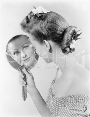 Reflection of a young woman, looking in a mirror