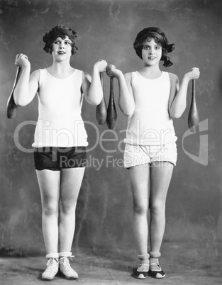 Two women exercising with juggling pins