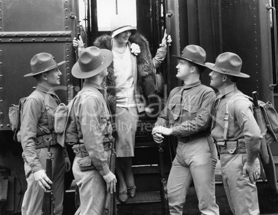 Woman being greeted by four soldiers