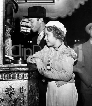 Father and daughter buying movie tickets