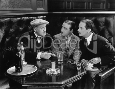 Three men sitting together at a bar