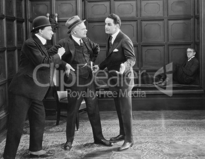 Three men standing together arguing