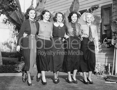 Five women posing in a back yard