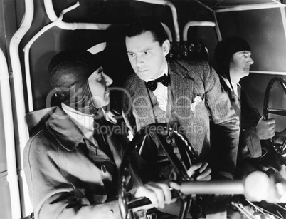 Three men inside of the cockpit of an airplane