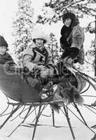 Three women sitting in a sled