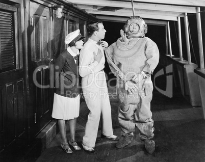 Two people looking in shock at a diver in a divers suit