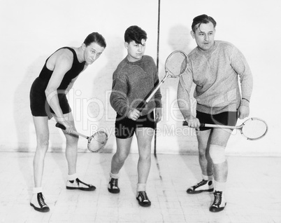 Three men playing squash
