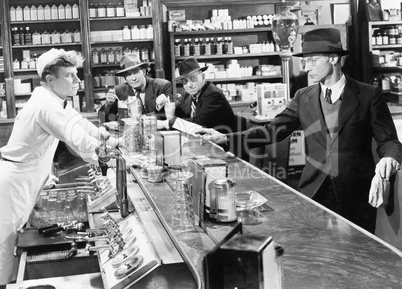 Four men at a soda fountain