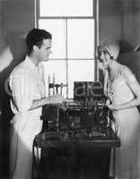 Woman smiling at a man next to an editing machine
