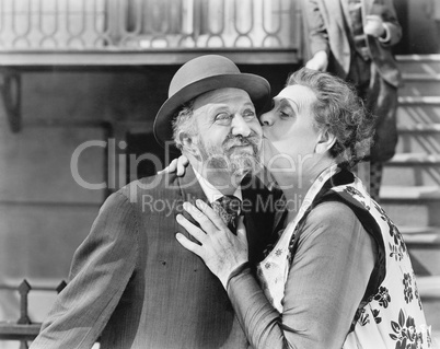 Woman kissing a man on his cheek