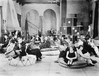 Group of people sitting on oversized cushions in a hall