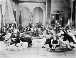 Group of people sitting on oversized cushions in a hall