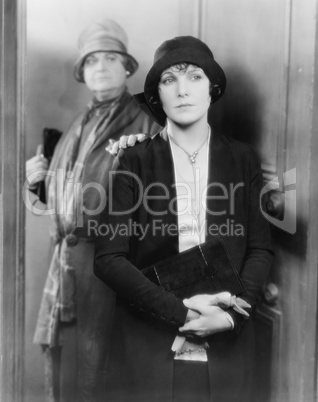 Two women standing together at a door