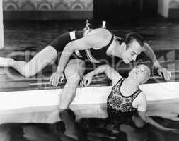 Man bending over to kiss a woman in a swimming pool
