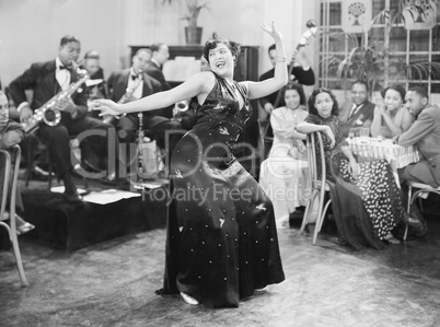 Zaftig woman performing a dance in front of a group of people in a restaurant