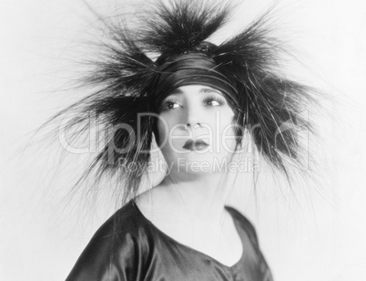 Elegant young woman looking serene in a feather hat