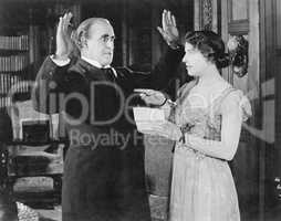 Woman with a letter in her hand pointing at a man