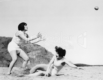 Two women playing with a ball at the beach