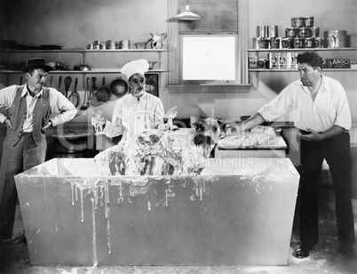 Chef and men wash a dog in the kitchen