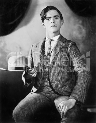 A man posing with his hat