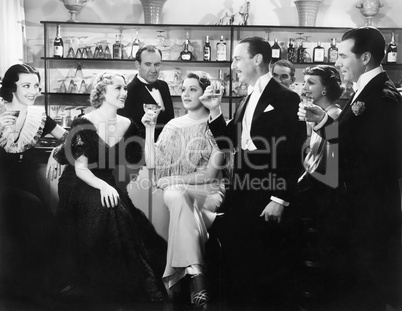 Elegant group of people at a bar toasting a woman