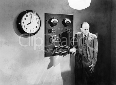 Man standing next to an electrical switch