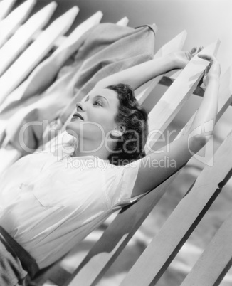Woman stretching out on a picket fence