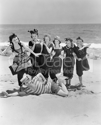 Young man with a group of young women at the beach