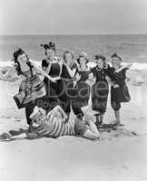 Young man with a group of young women at the beach