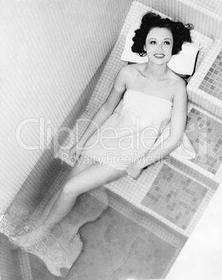 Woman lying on the steps of a spa bath
