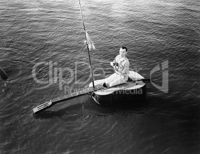Man sitting on a guitar sailboat