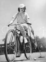 Woman on a bicycle playing polo