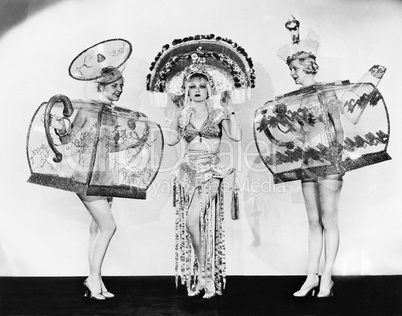 Three woman in ornate teapot costumes