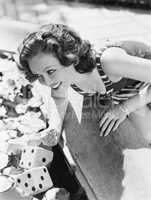 Woman leaning over a fountain with dice in the water