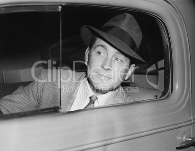 Man sitting in a car looking out the window