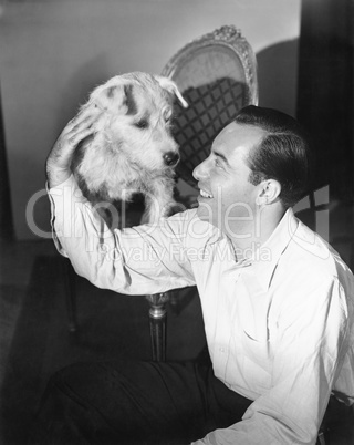 Man sitting on the floor petting his dog