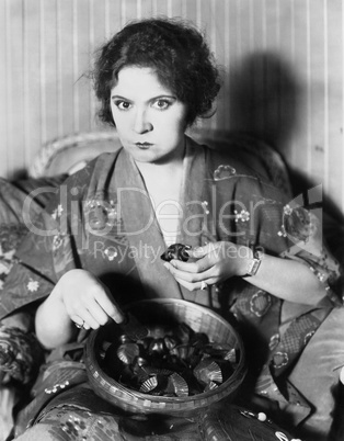 Woman eating chocolates out of a bowl