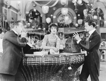 Young woman in a store and ignoring two men with megaphones